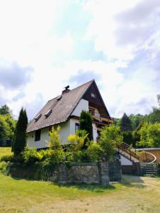 una casa blanca con techo de gambrel en Chata Mraveneček en Lipova Lazne