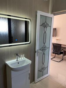 a bathroom with a sink and a shower backdoor at The Ace Hotel in Lusaka