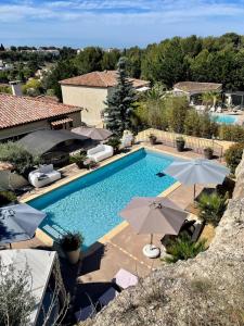 una imagen de una piscina con sombrillas en Villa fiora classée 4 étoiles, en Martigues