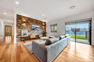 a living room with a couch and a brick wall at Velo Station in Porepunkah