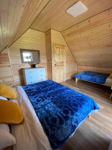 a bedroom with a bed in a wooden cabin at Zielony Zakątek Lasówka in Lasowka
