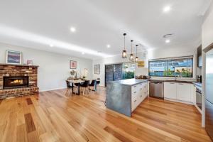 a kitchen and living room with a table and a fireplace at Velo Station in Porepunkah