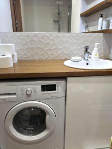 een badkamer met een wasmachine en een wastafel bij Apartament w sercu Malborka in Malbork