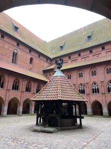 a large brick building with a small tower in front of it at Apartament w sercu Malborka in Malbork