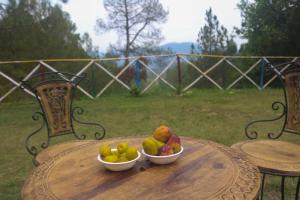 two bowls of fruit sitting on a wooden table at Naughar Homestay in Almora