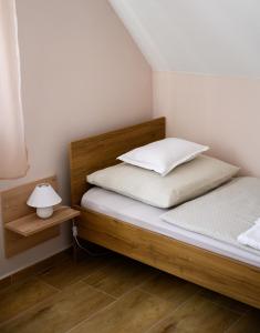 una camera con 2 letti e una lampada su un pavimento in legno di Dorka Vendégház a Gyomaendrőd