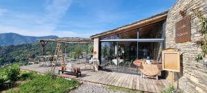 un edificio con terraza con mesas y sillas en Domaine Colonna-Santini, Gite Piscine, Sauna, Spa en Porri