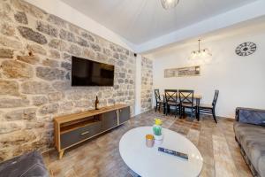 ein Wohnzimmer mit einer Steinmauer in der Unterkunft Happy Home Apartments in Kotor