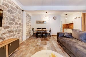 ein Wohnzimmer mit einem Sofa und einem Tisch in der Unterkunft Happy Home Apartments in Kotor