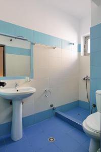 un bagno blu e bianco con lavandino e servizi igienici di Hotel Argjiro a Sarandë