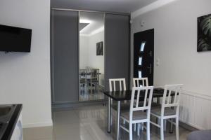 ein Esszimmer mit einem schwarzen Tisch und weißen Stühlen in der Unterkunft Domki do wynajęcia in Wolsztyn