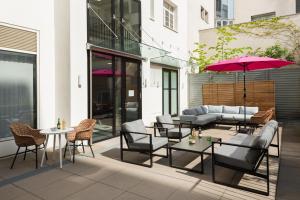 een patio met stoelen en tafels en een parasol bij master Mirabell in Salzburg