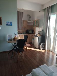 una cucina con un tavolo e sedie in una stanza di Beachfront apartment a Rethymno