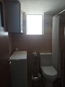 un piccolo bagno con servizi igienici e finestra di Beachfront apartment a Rethymno