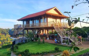 a large house with a deck on a lawn at Dambri View Garden in Buôn Bedeur