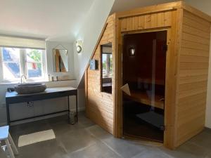 a bathroom with a sink and a wooden cabinet at Sealounge in Dassow