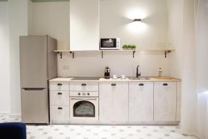 cocina con armarios blancos y nevera en Casa Alberola Apartments, en Alicante