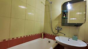 La salle de bains est pourvue d'un lavabo, d'une baignoire et d'un miroir. dans l'établissement Василя Стуса 10 City Rooms, à Bila Tserkva