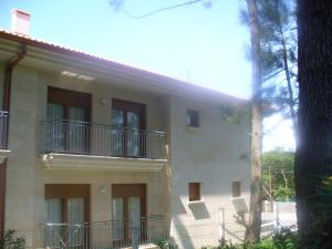 un edificio con balcones en un lateral en Sanxenxorural - Apartamentos La Rana, en Sanxenxo