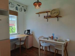 a kitchen with a table and a clock on the wall at Ihana yksiö joen ja torin lähellä in Joensuu