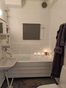 a white bathroom with a tub and a sink at Ihana yksiö joen ja torin lähellä in Joensuu