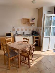 eine Küche mit einem Tisch und Stühlen im Zimmer in der Unterkunft Studio Soulac centre et plage in Soulac-sur-Mer