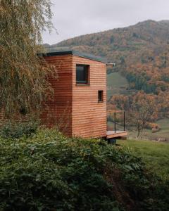 a tiny house on a hill with a bench at kiva cabin in Horné Hámre