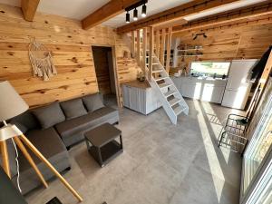 a living room with a couch and a kitchen at Domki na Mazurach - Marksewo in Szczytno