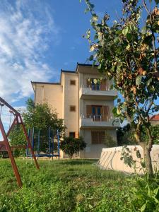 ein Gebäude mit einem Spielplatz vor einem Hof in der Unterkunft Villa Apollonia Guest House in Fier