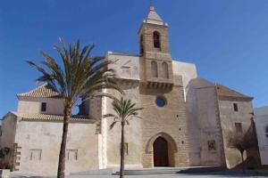 uma igreja com duas palmeiras em frente em Isabelita em Rota