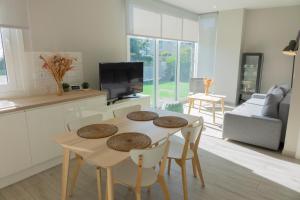 cocina y sala de estar con mesa y sillas en Apartamentos Dunas de Samil en Vigo