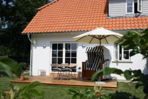 a house with a wooden deck with an umbrella at Sealounge in Dassow