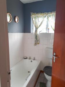 a bathroom with a bath tub and a toilet at Franskraal cosy 3 bedroom in Franskraalstrand