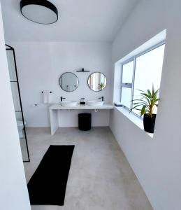a white bathroom with a sink and a mirror at Number 3 in Plettenberg Bay