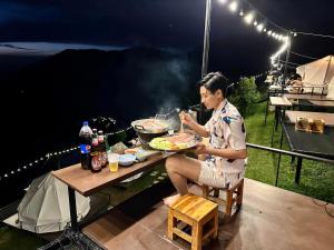 Un uomo seduto a un tavolo con un piatto di cibo di Heaven Khaokho (เฮฟเว่น) a Khao Kho
