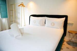 una camera da letto con letto, lenzuola e cuscini bianchi di Casa Alberola Apartments ad Alicante