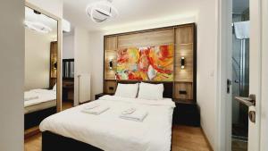 a bedroom with a large white bed and a mirror at AlyaTeras in Istanbul