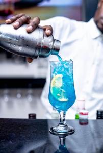 a person is pouring a drink into a glass at The Ace Hotel in Lusaka