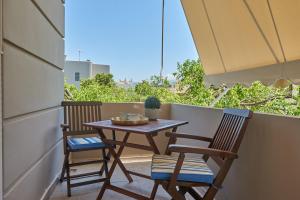 a small table and two chairs on a balcony at Luxurious house near the sea in Kato Daratso