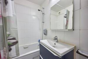 biała łazienka z umywalką i prysznicem w obiekcie Galys - Appt à 1 km de la plage w mieście Courseulles-sur-Mer