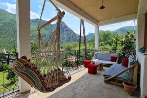 een veranda met een hangmat en uitzicht op de bergen bij ILIS House Matka in Skopje