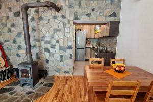 uma cozinha com um fogão a lenha e uma mesa de madeira em ILIS House Matka em Skopje