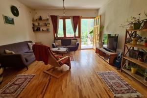 a living room with a couch and a tv at ILIS House Matka in Skopje