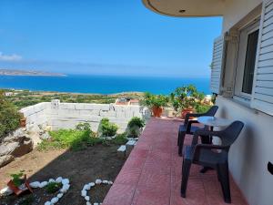 taras z krzesłami i widokiem na ocean w obiekcie panorama apartment w mieście Agia Fotia