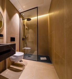 uma casa de banho com um chuveiro e um WC. em Hotel Apartamentos Hamus em Conil de la Frontera