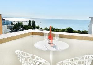 - une table avec 2 verres et une bouteille de vin sur le balcon dans l'établissement Ocean Dream, à Międzyzdroje