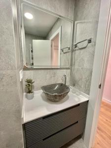 baño con lavabo y un gran tazón de piedra. en Apartamento TDC12 en Gijón