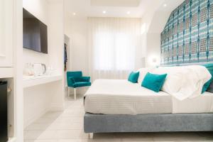 a bedroom with a large bed with blue pillows at L'INCANTO DI CIOFFI ROOMS in Sorrento