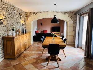 a living room with a table and a couch at Le Mas de Maellou - Maison de vacances en Drôme Provençale in Grillon