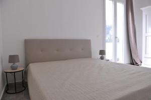 ein weißes Schlafzimmer mit einem großen Bett und einem Fenster in der Unterkunft Villa Rachele in Sant'Isidoro
